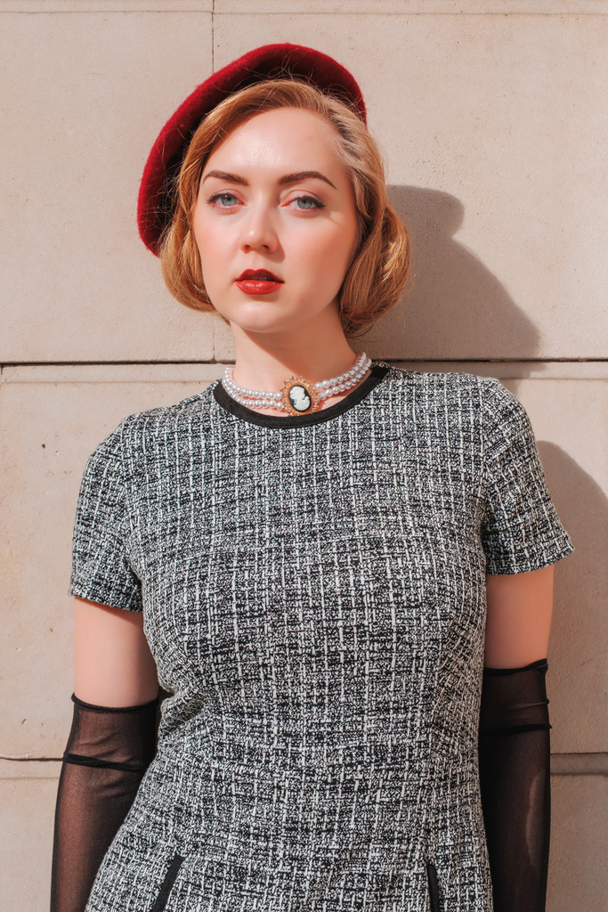 Leaning against a wall, relaxed steady stare