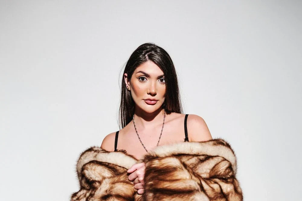 One shoulder raised forward pose: Bringing one shoulder up and forward while the other stays back breaks the symmetry of a straight-on portrait and gives it a slight, deliberate twist.