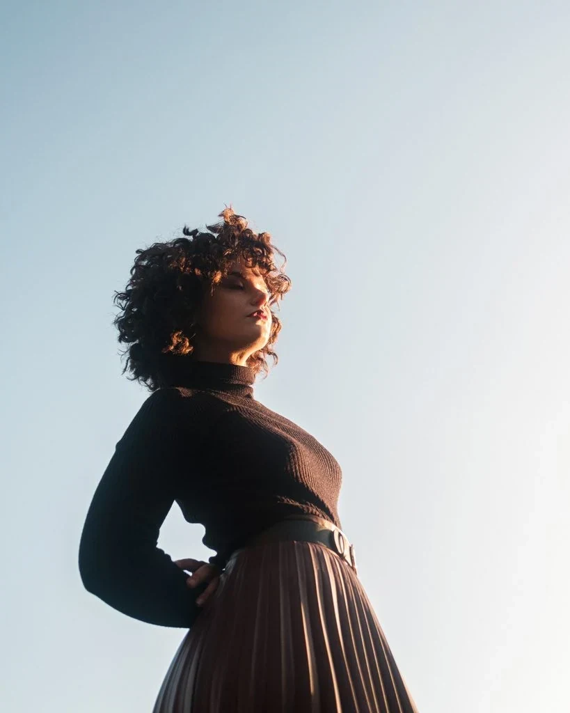 Arms back, pointing to the sun pose: Leaning backward with your arms held behind you and your face turned up towards the sun opens up your whole chest and neckline to the light.