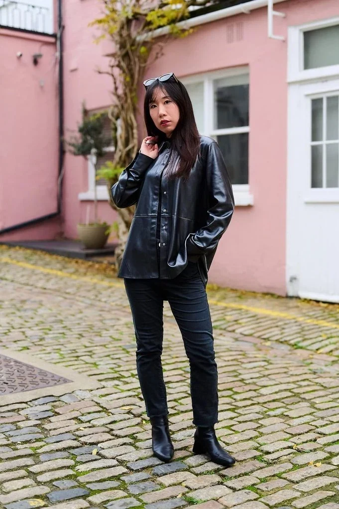 Bag over the shoulder, hands in pockets pose: Slinging a bag over one shoulder and tucking both hands into your pockets while leaning slightly gives a simple standing pose a relaxed, unbothered edge.