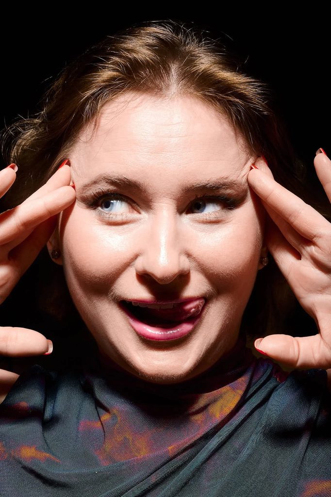 Unfiltered laughing expression, hands near face